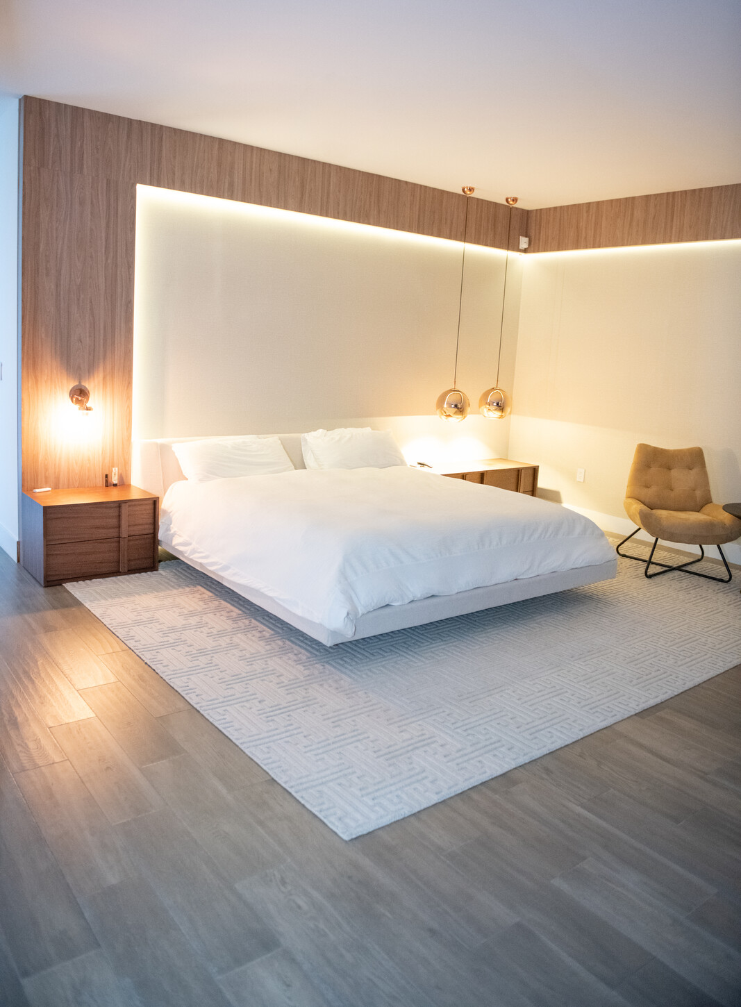 Custom wood panel headboard wall with integrated sconce lighting in Weston Botanico primary bedroom