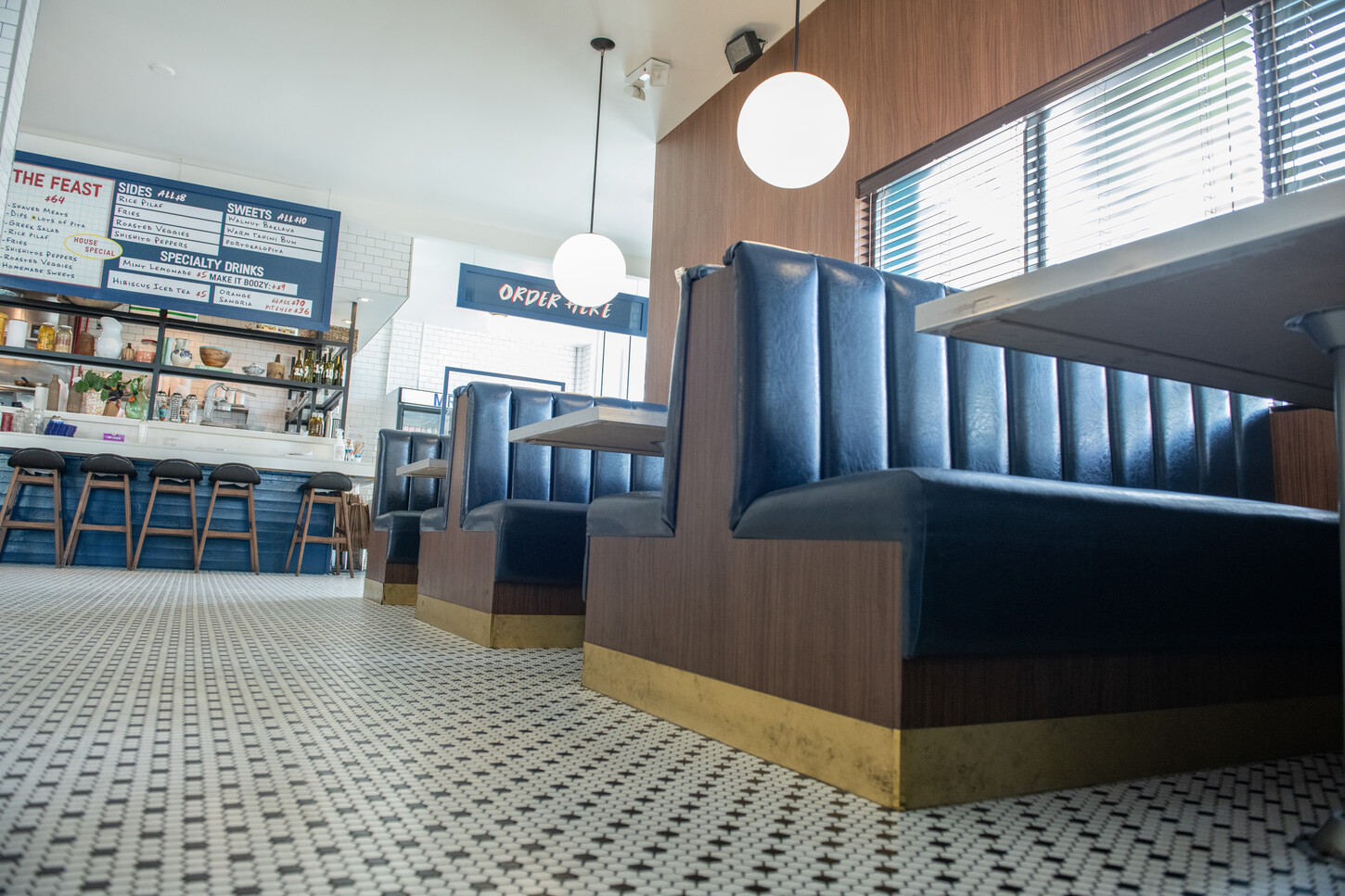 Black channel-tufted booth seating with menu board wall view