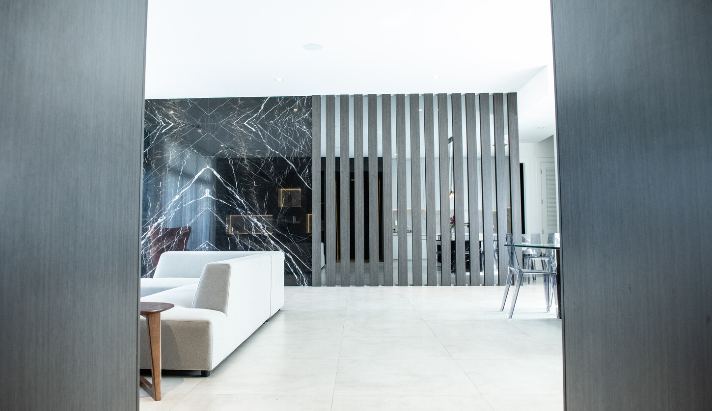 Weston Botánico Modern Residence black marble fireplace and wood slat wall by CM Custom Design