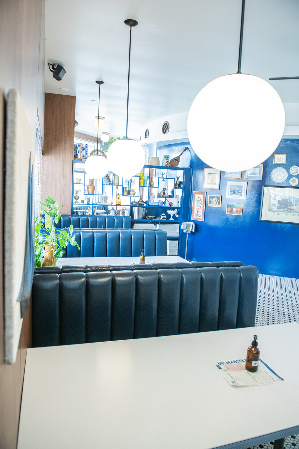 Blue accent wall with gallery frames and globe pendant lighting