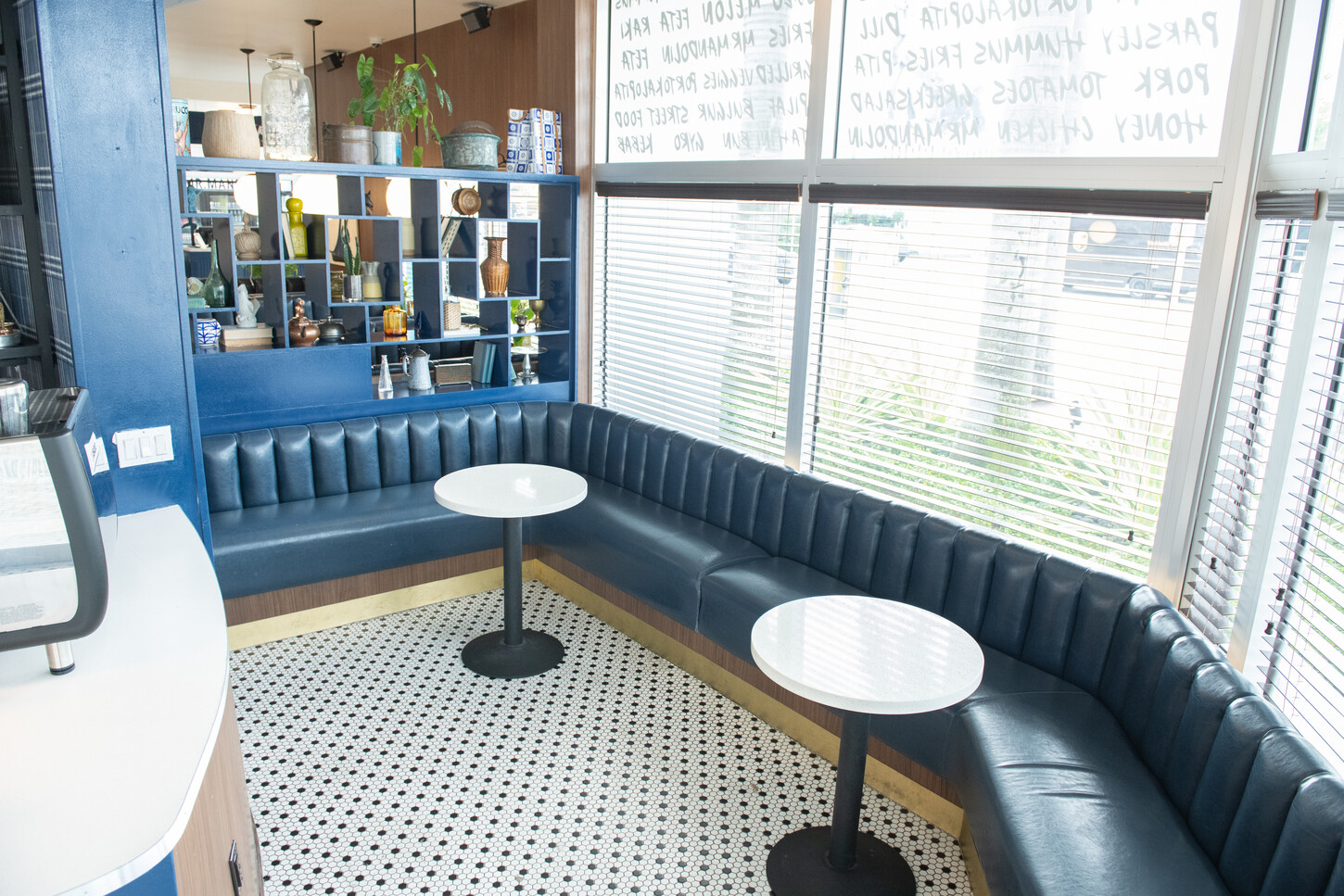 Blue booth seating with standalone cafe table and window light