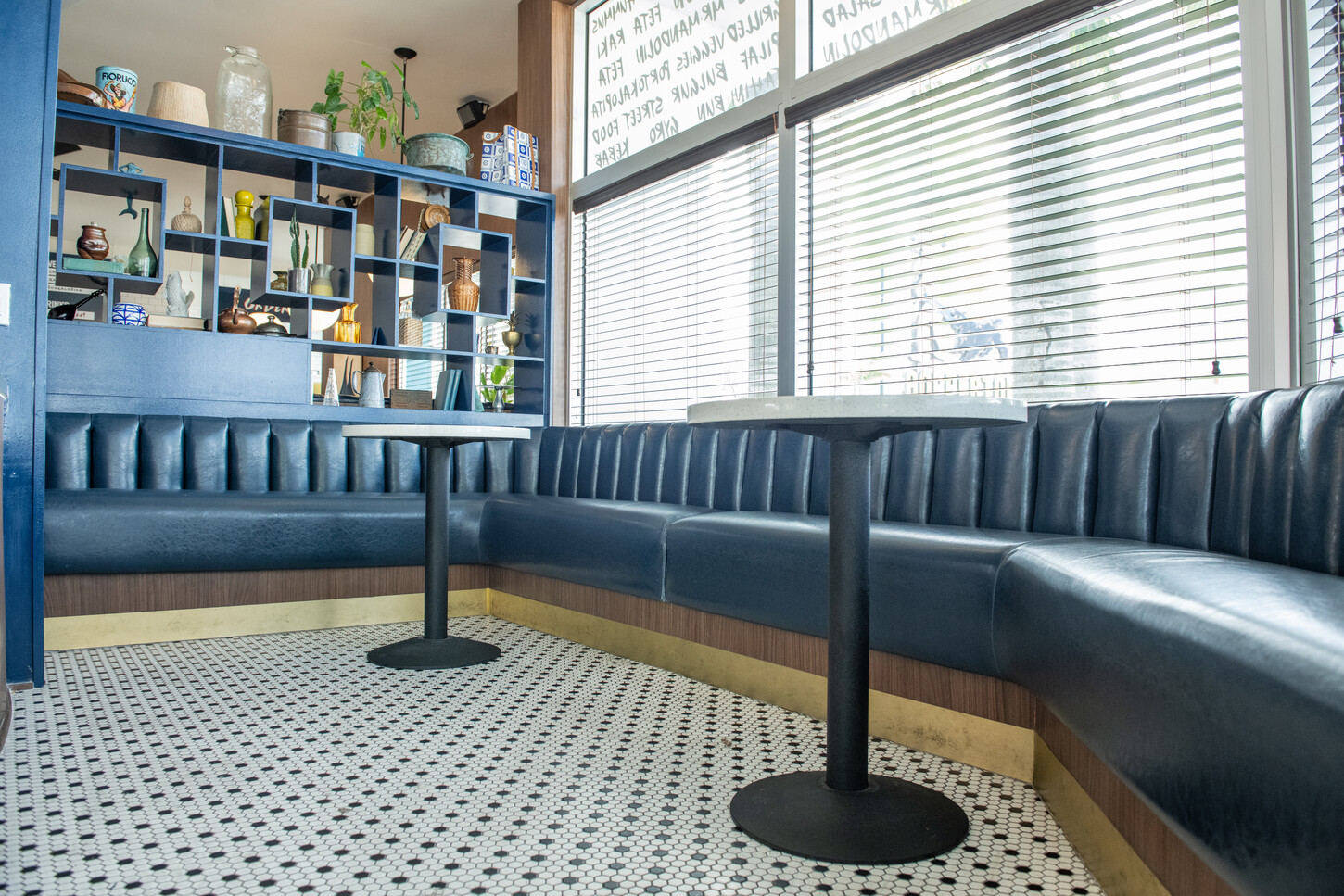 Blue curved booth seating with wood base and standalone table