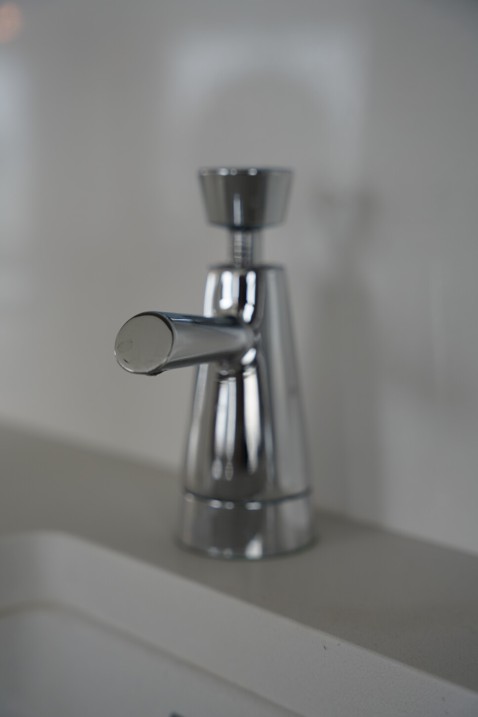 Chrome bathroom faucet detail on a natural stone vanity countertop