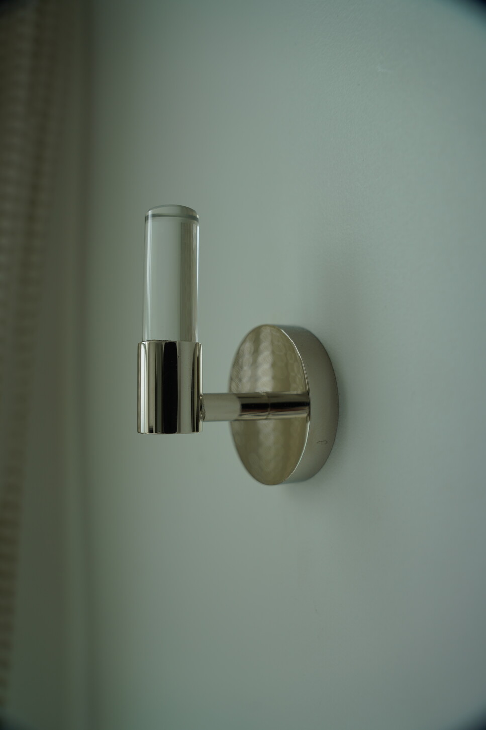 Polished chrome bathroom hardware detail against a marble wall