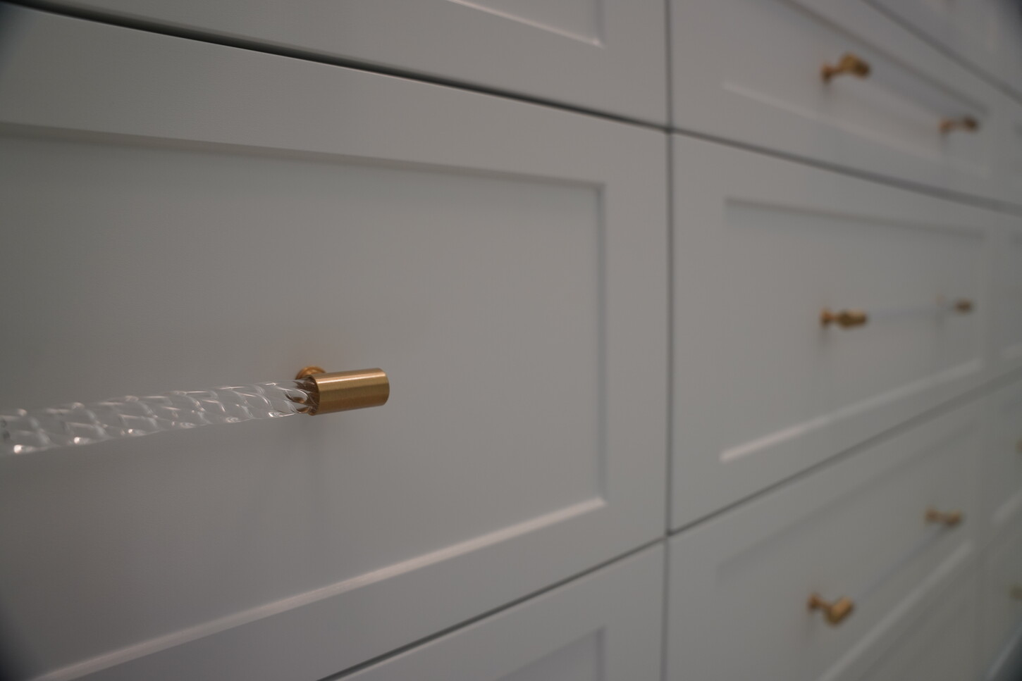 Shaker cabinet drawer fronts with brass and acrylic hardware detail