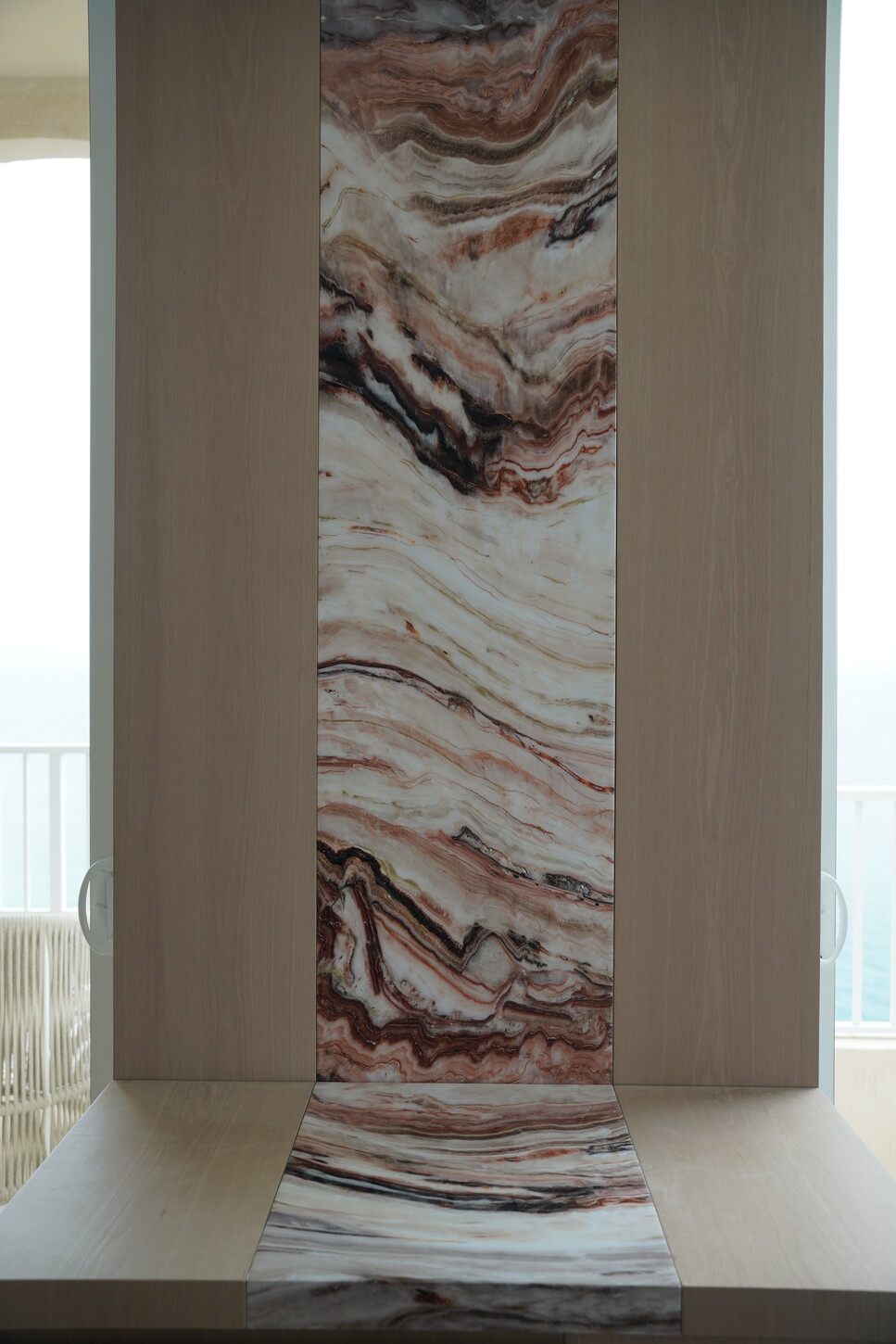 Custom wall panel with epoxy-finished imitation stone wrapping from wall to console in a Boca Raton luxury interior finishing project