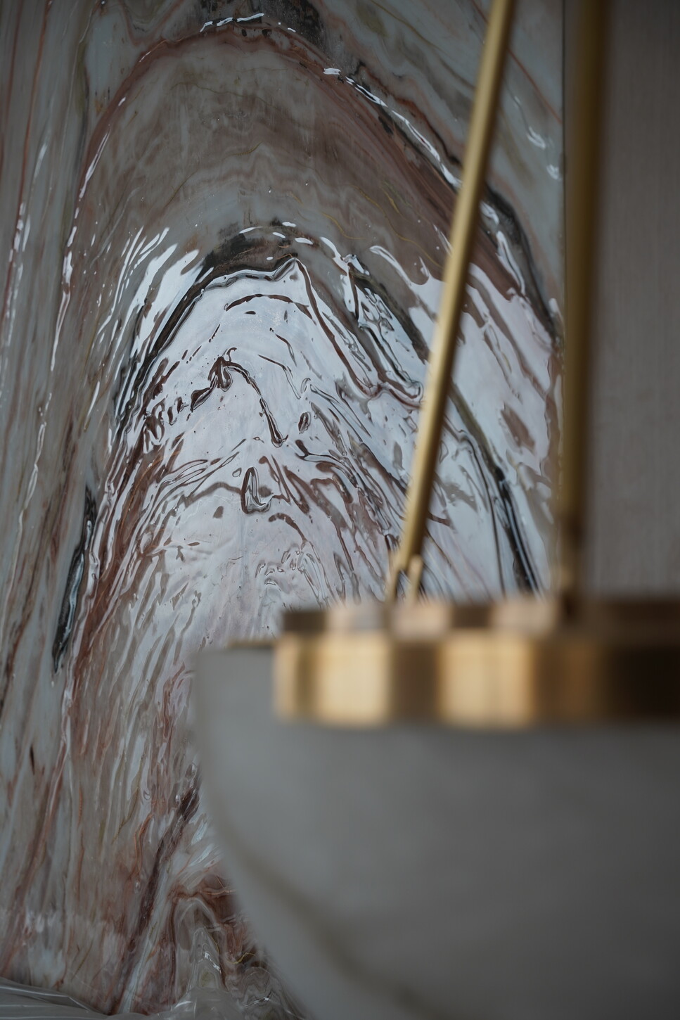 Epoxy-finished wall cladding panel with a pendant light detail in a Boca Raton primary suite
