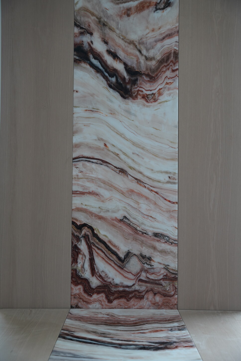 Full-height custom wall panel with epoxy finish and bookmatched imitation stone veining