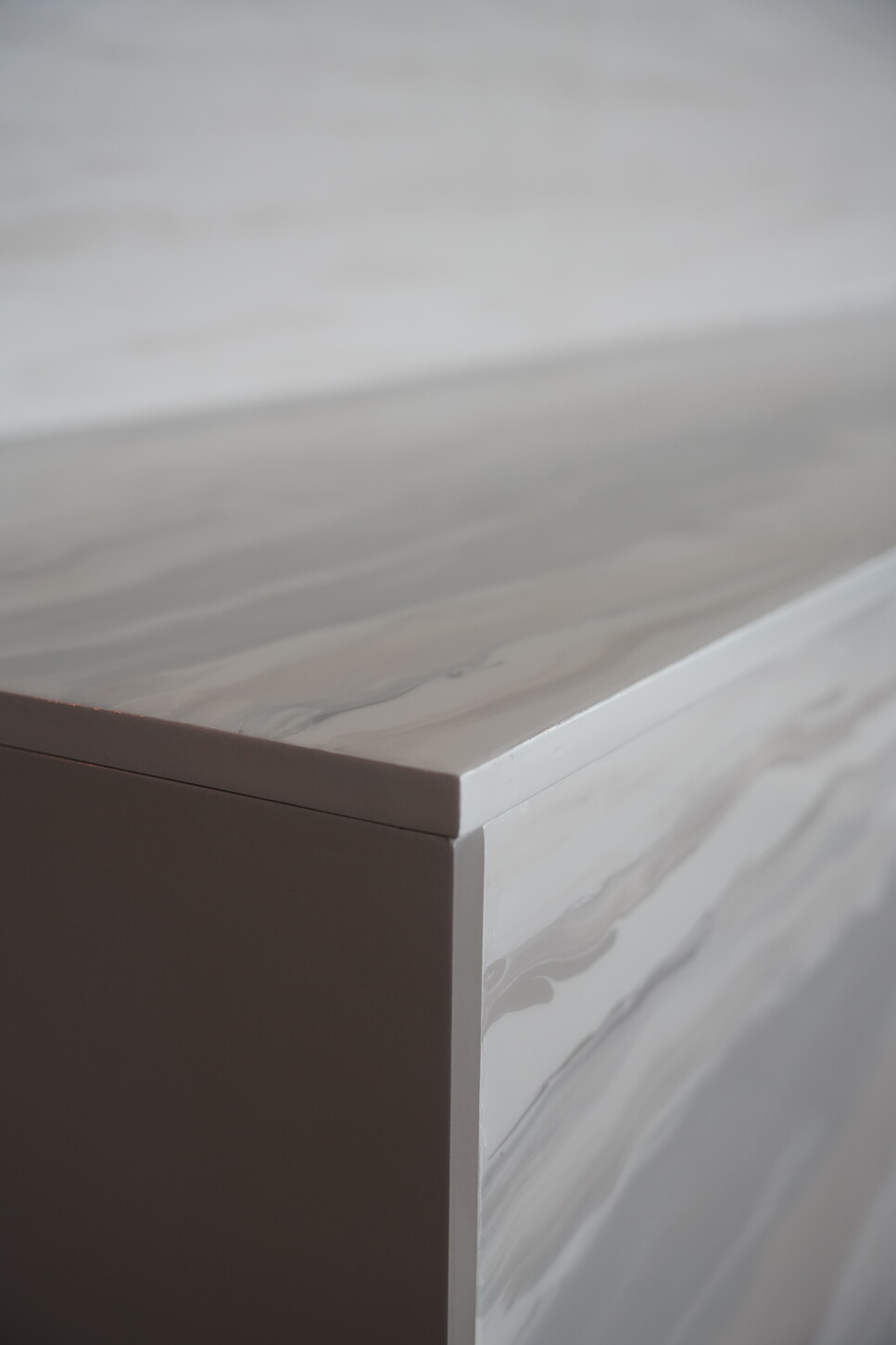Close-up of an imitation stone console edge with a high-gloss epoxy finish