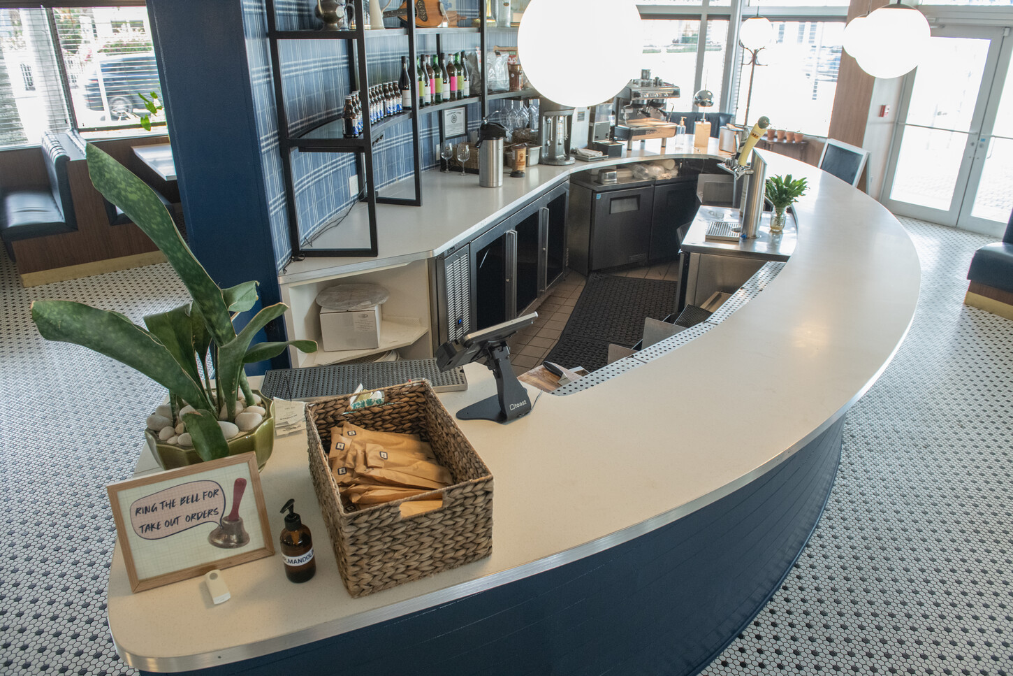 Curved bar back shelving with bottle display and pendant lighting