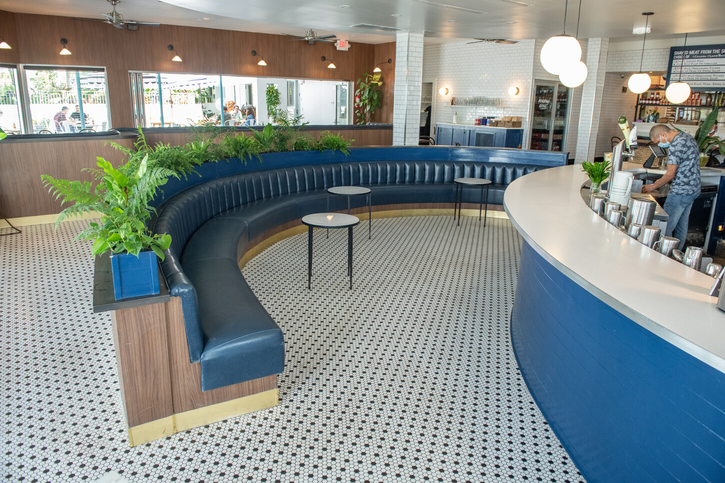 Curved bar with blue planter boxes beside wraparound windows