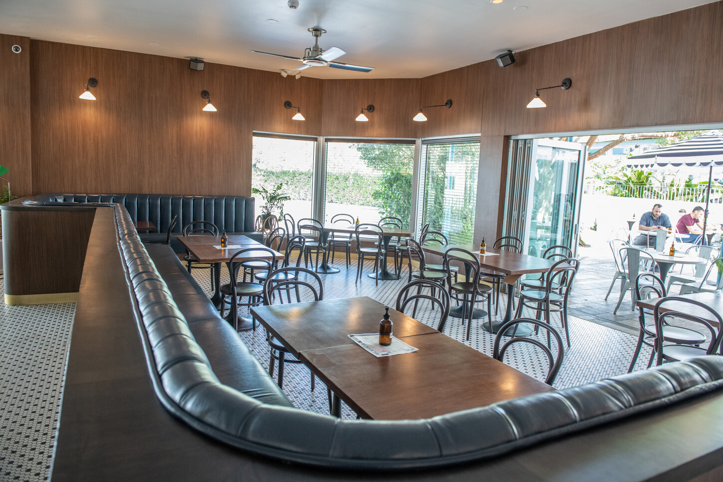 Curved navy banquette booth seating with wood tables in the restaurant