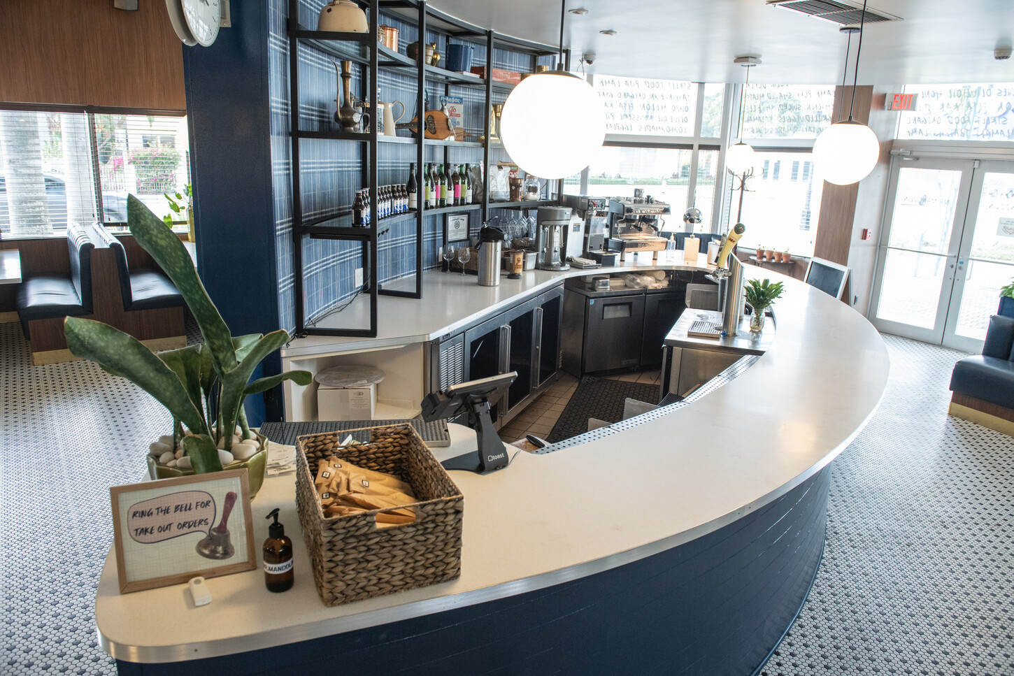 Curved white marble bar with blue base and shelving detail