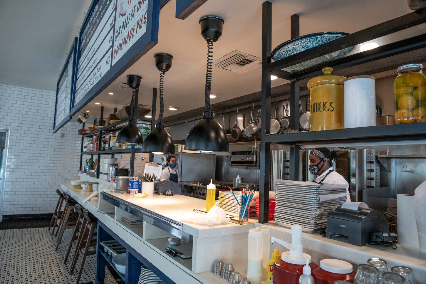 Dark wood booth seating with cafe tables and pendant lighting