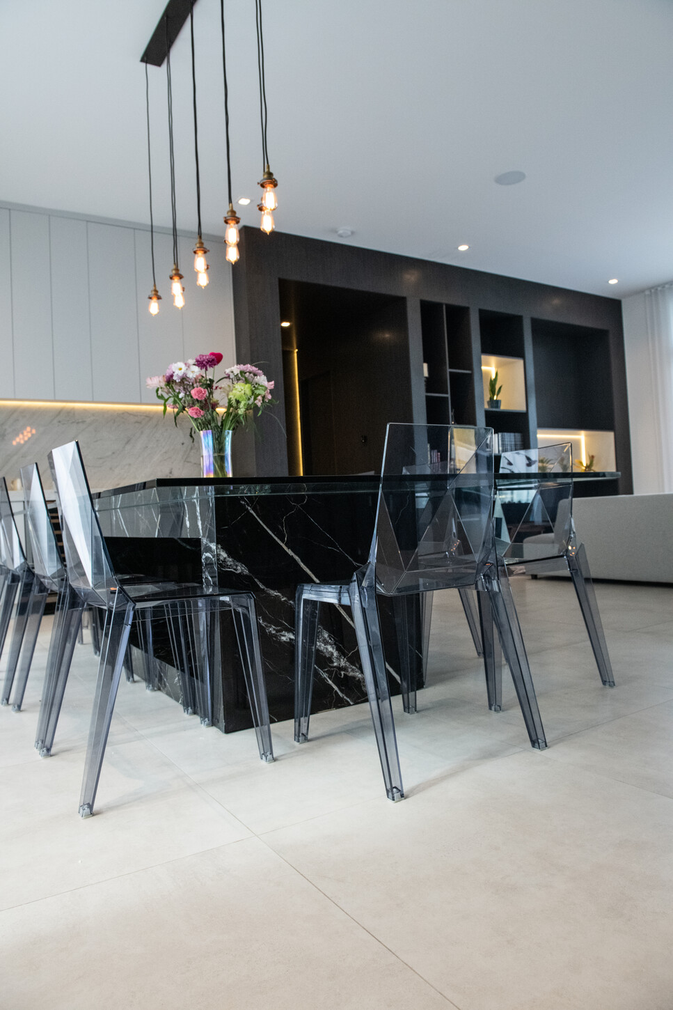 Custom marble dining table base with glass top extending the marble design language into furniture in Weston Botanico residence