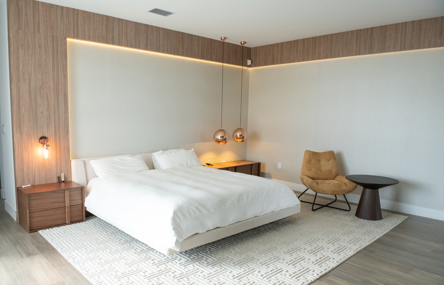 Hallway view of built-in TV and fireplace cabinetry with integrated lighting in Weston Botanico residence