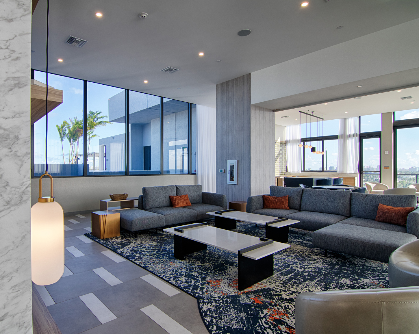 Modern high-rise living room lounge with panoramic city and ocean views, designed by CM Custom Design in Miami