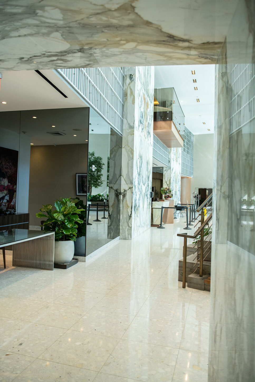 Marble-clad atrium with columns and staircase in a Miami luxury condo building