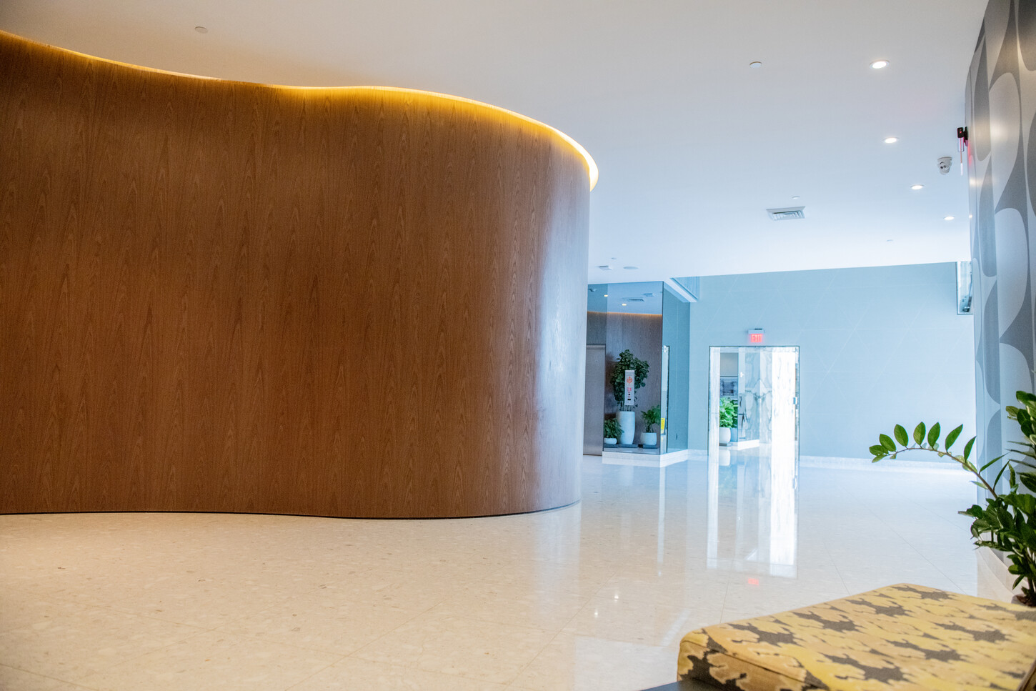 Curved custom millwork wall in a Miami condo lobby reception area
