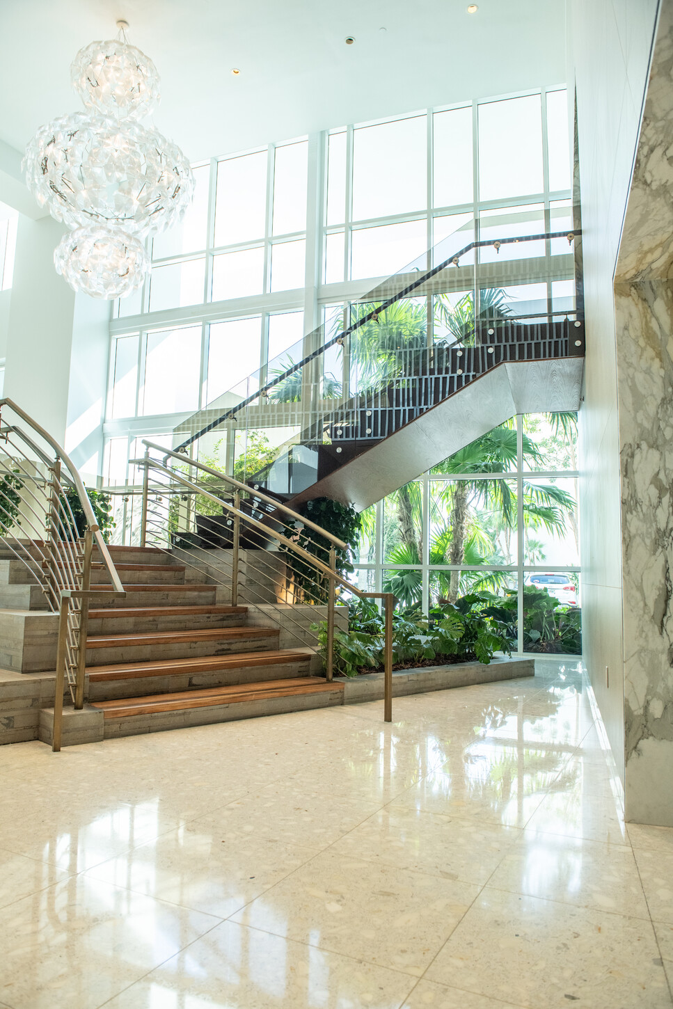 Floating staircase with crystal chandelier in a Miami condo lobby