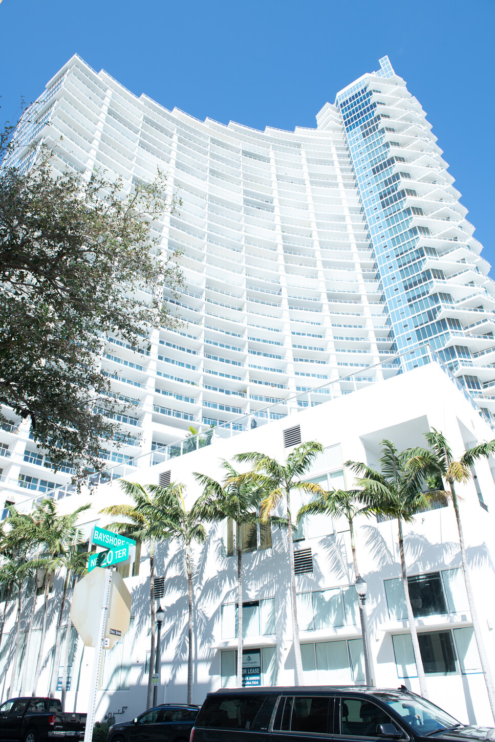 Exterior facade of a Miami luxury condo tower with palm trees