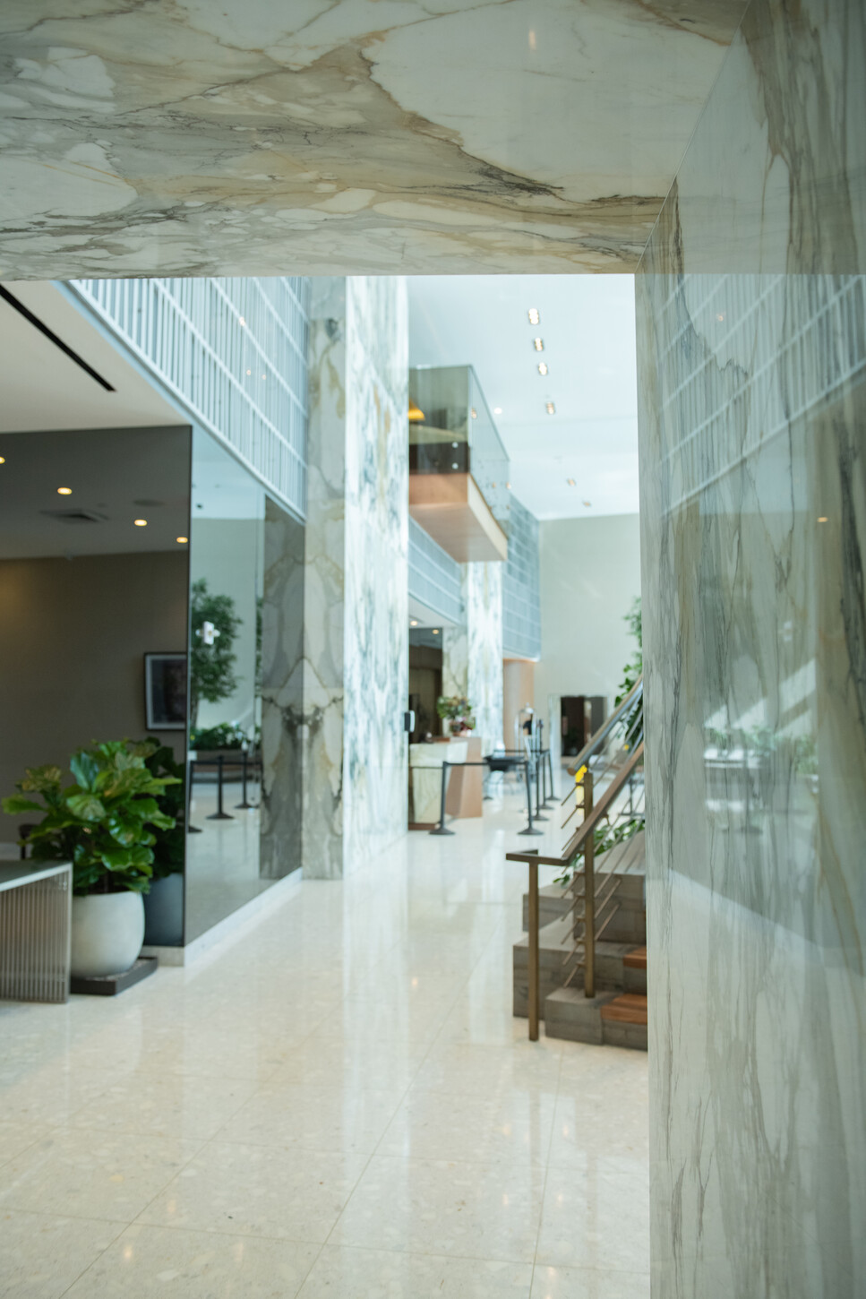 Marble hallway leading to the reception desk in a Miami residential lobby