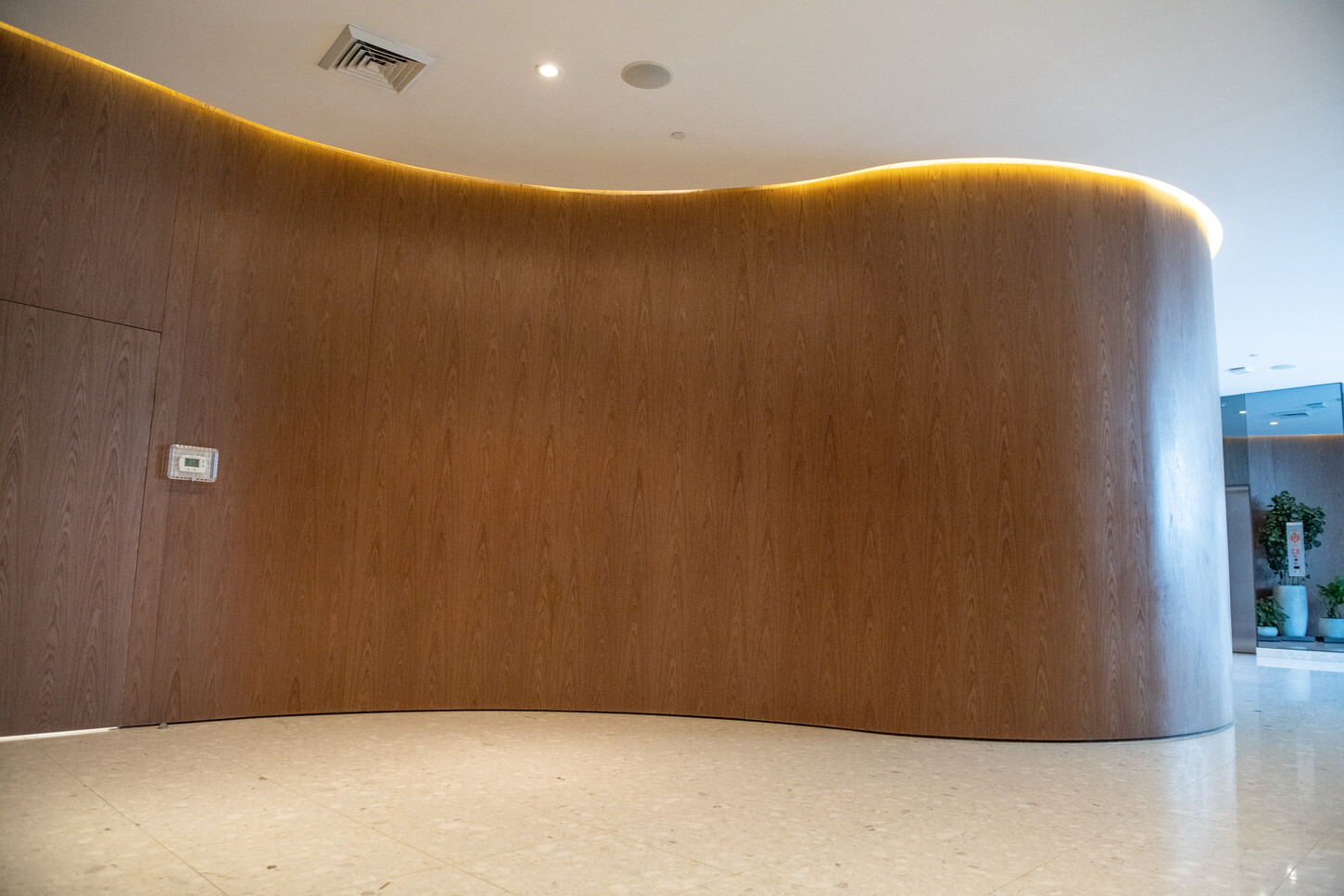 Curved custom wood paneling reception wall in this Miami Luxury Residential Millwork project’s lobby