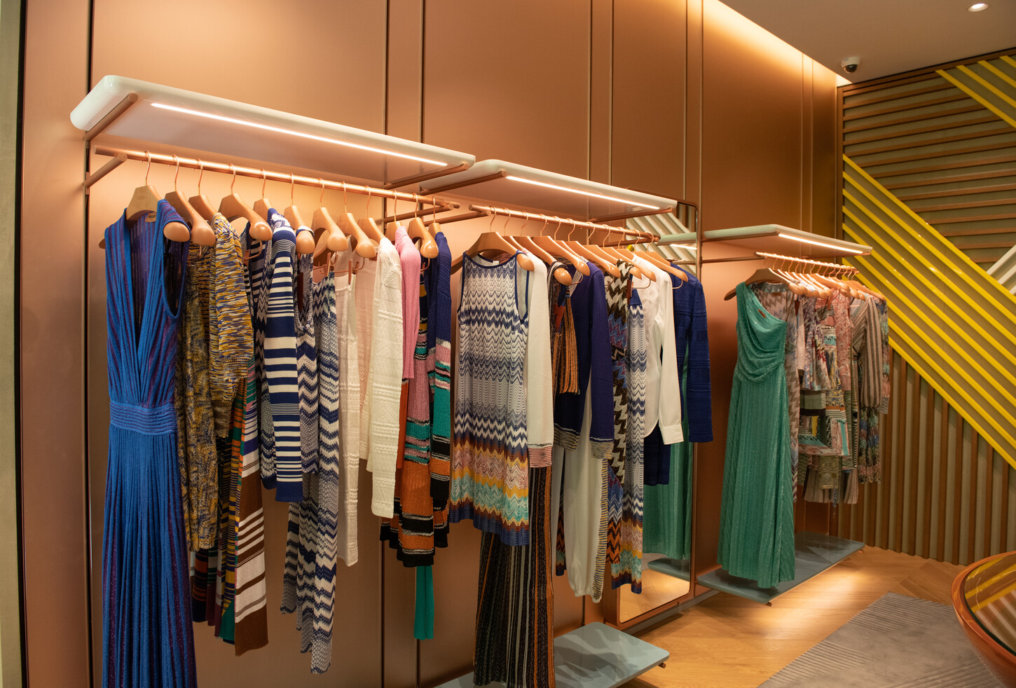 Custom wall paneling and display racks with integrated LED lighting in the Missoni boutique