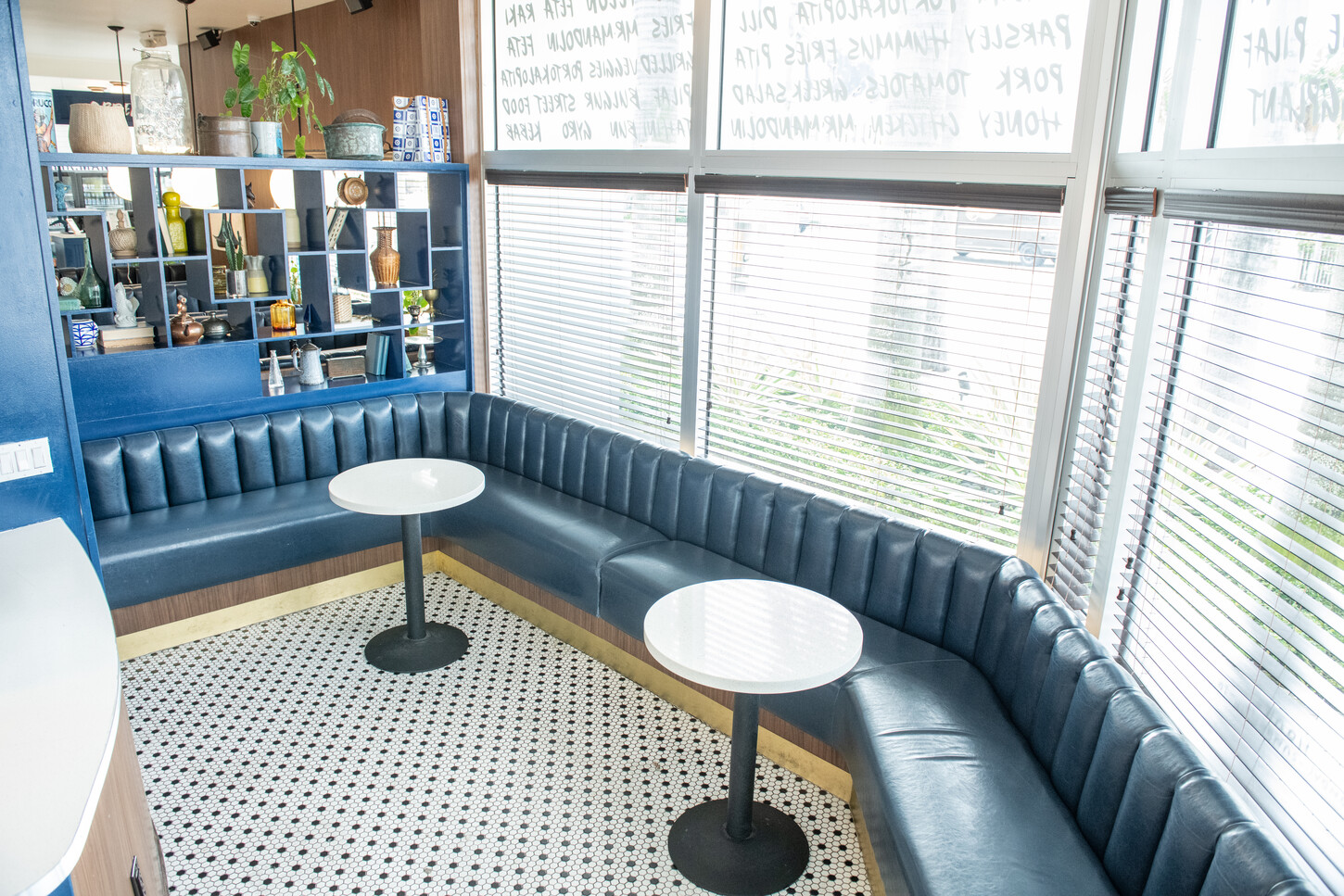 Open kitchen shelving and bottle display above a prep station counter