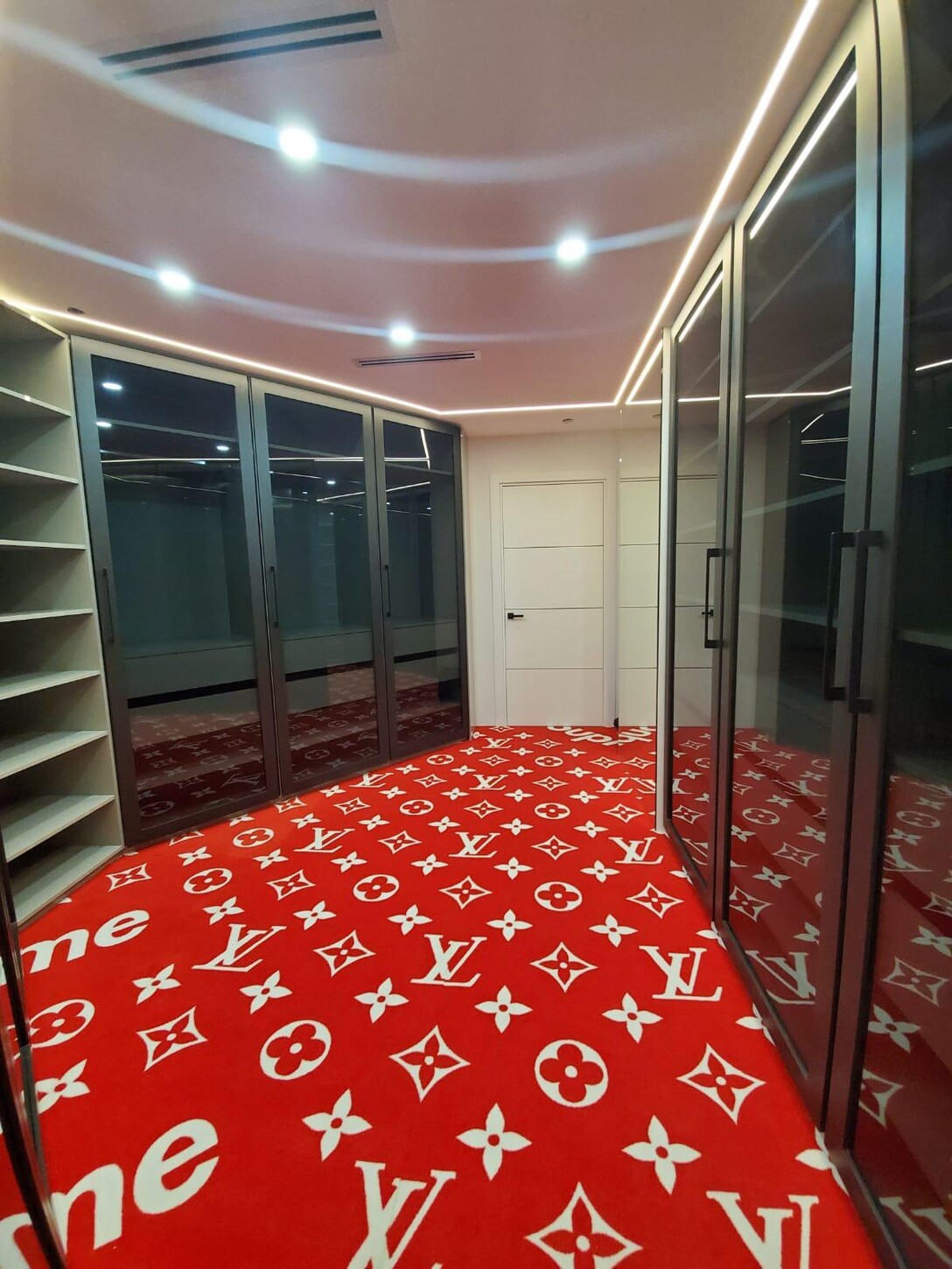 Custom closet with mirrored wardrobe doors and built-in shelving