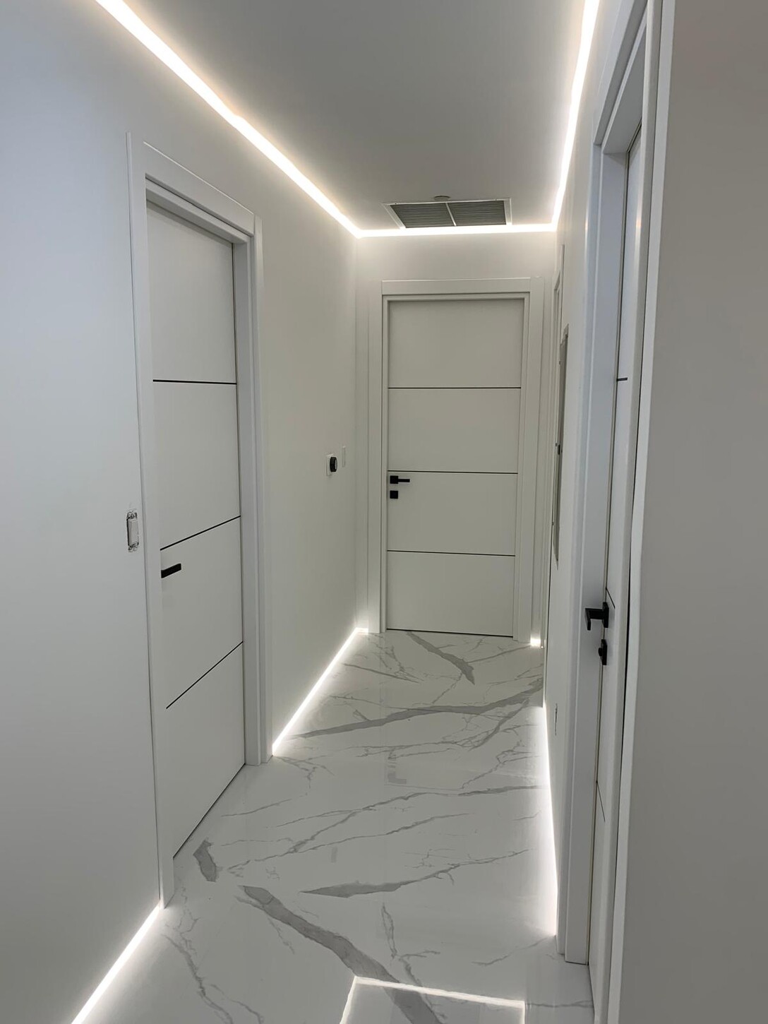 Hallway corridor with floating LED lighting along the ceiling and floor in this Midtown waterfront residence