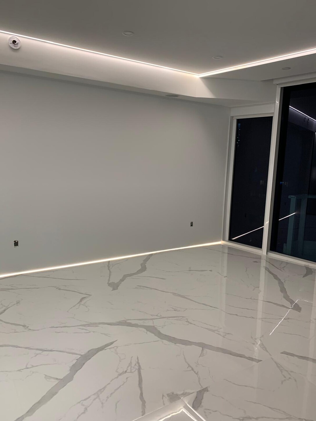 Frosted glass sliding door used as a room divider with book-matched flooring