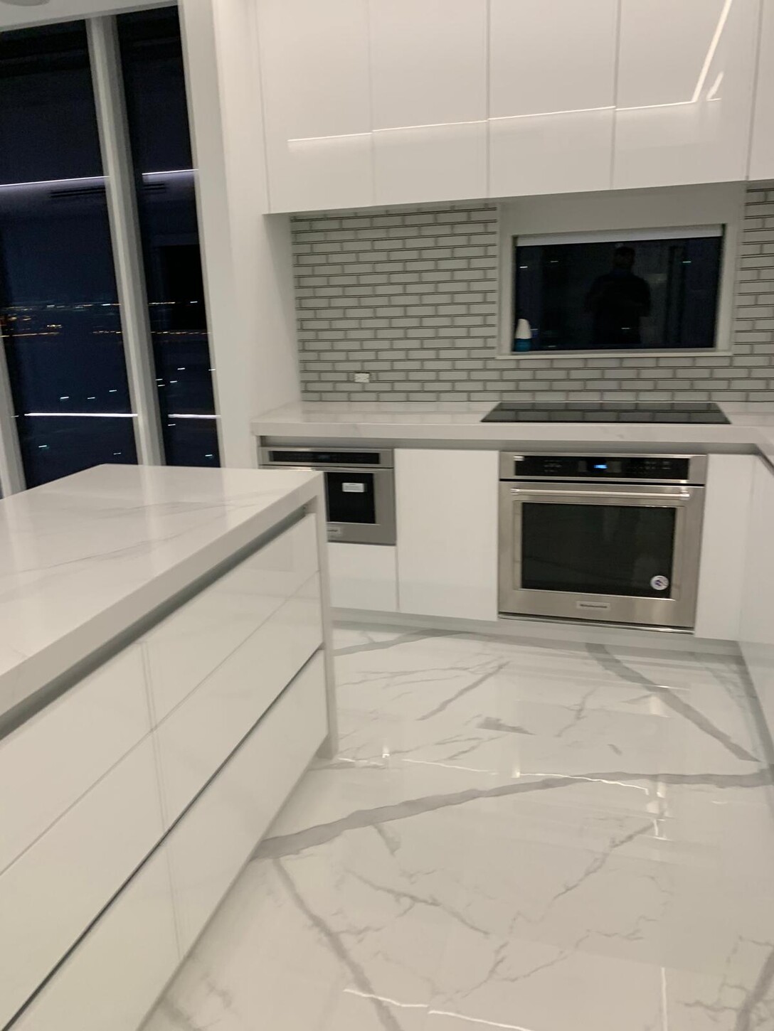 Custom kitchen cabinetry and refrigerator wall at night in this Midtown waterfront residence
