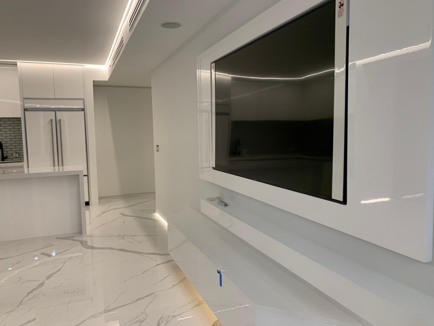 Living room with curved floor-to-ceiling windows and book-matched marble flooring at night