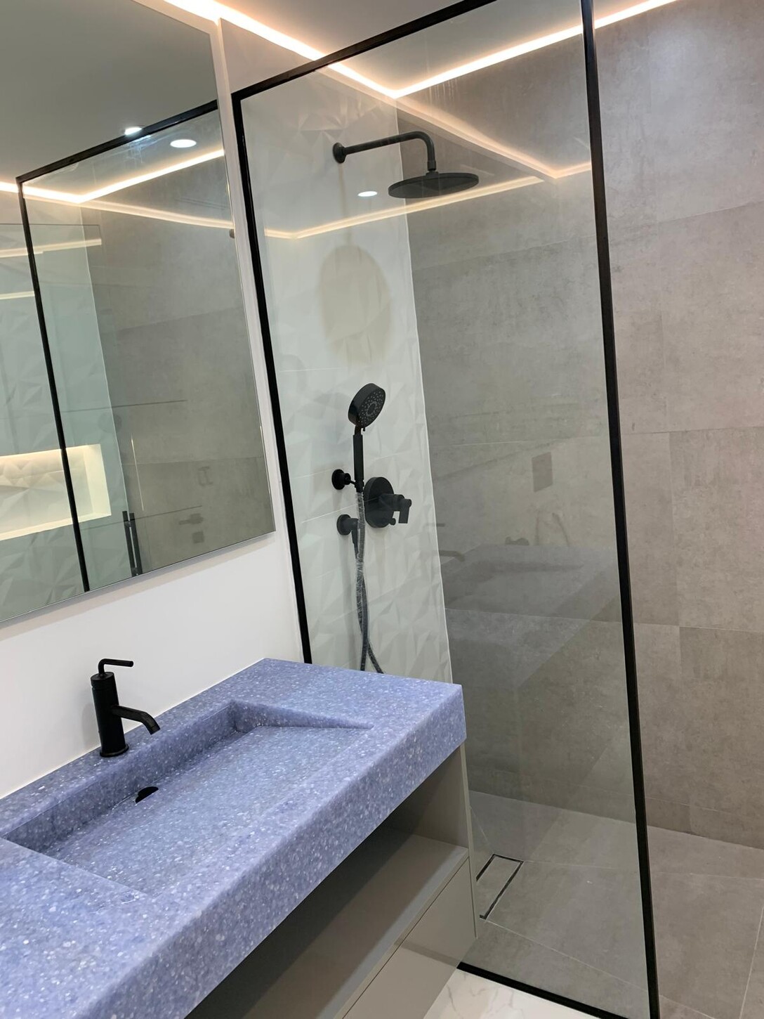 Living room with cove LED lighting and book-matched marble flooring in a Midtown Miami residence