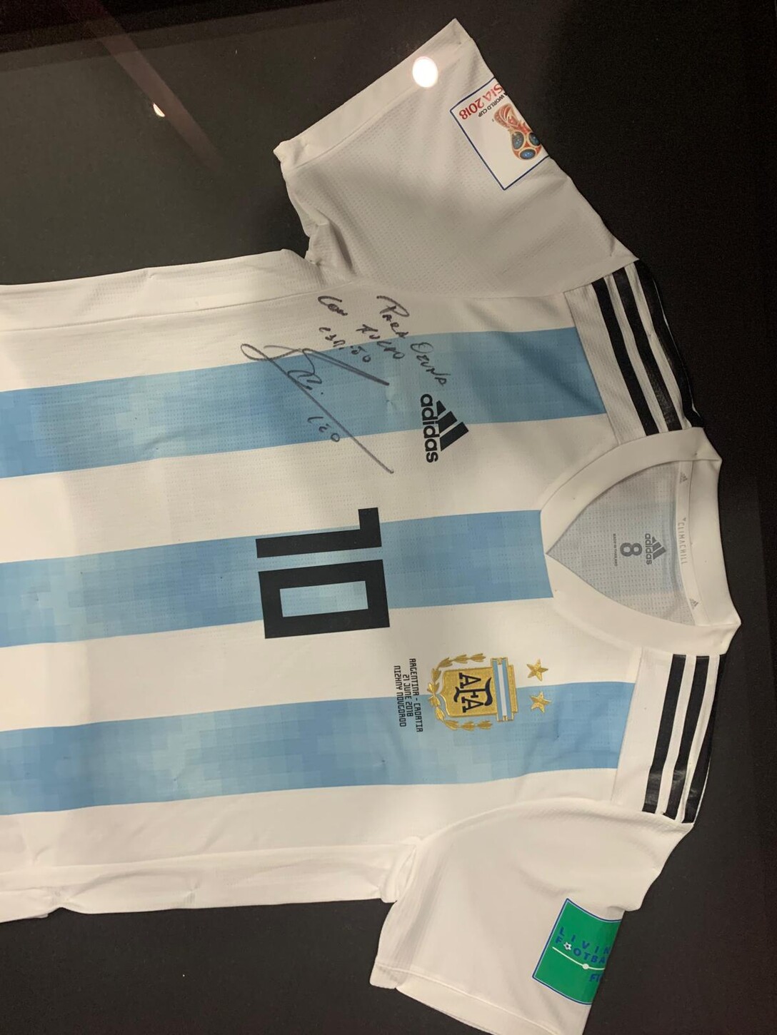 Close-up of a framed, signed Argentina national team jersey displayed in the residence