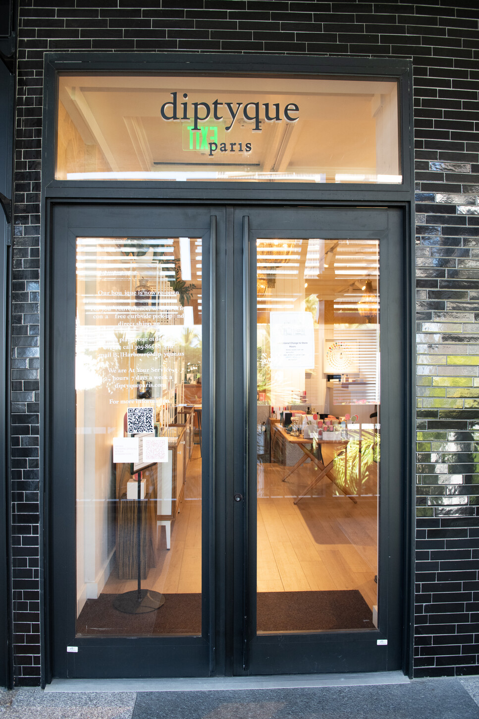 Storefront entrance of a Diptyque Paris boutique with custom black-framed glazing
