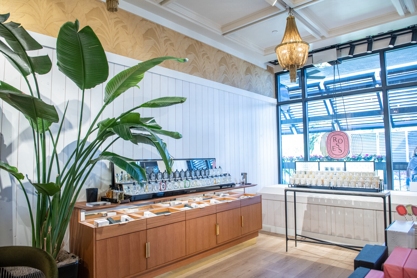 Custom white wall paneling and patterned accent wall in a Diptyque Paris boutique retail fit-out