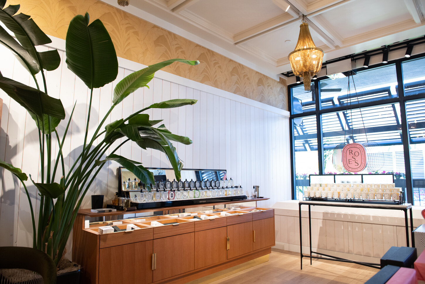 Close-up of custom wood fragrance counter with brass hardware in a boutique retail fit-out
