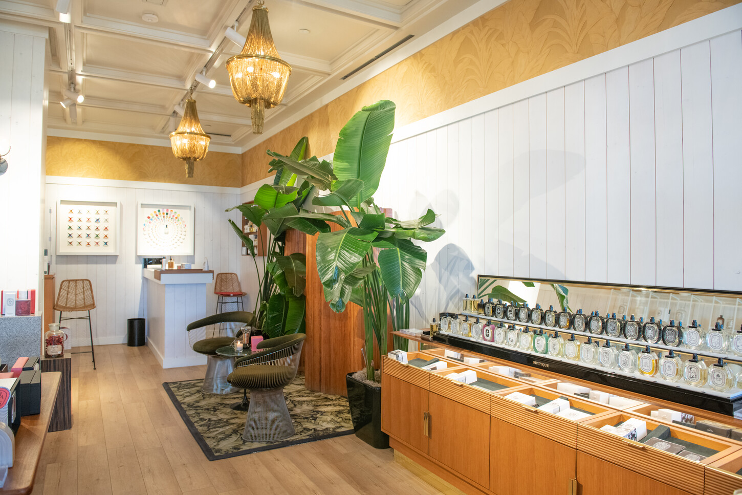 Custom lounge seating area with coffered ceiling and wall paneling in a Diptyque Paris boutique