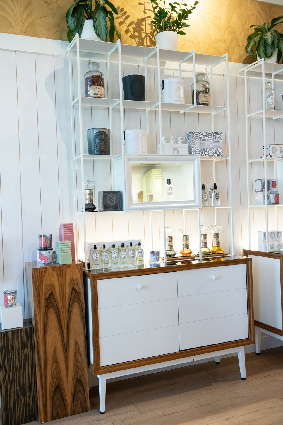 Detail of custom display shelving with mirror insert and wood-paneled base cabinet
