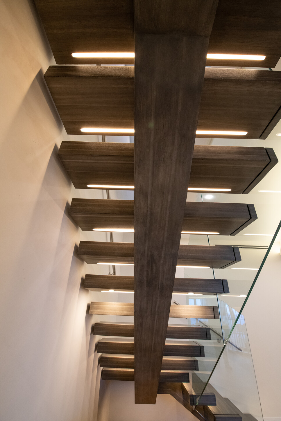 Close-up detail of custom oak tread and steel joinery on floating staircase