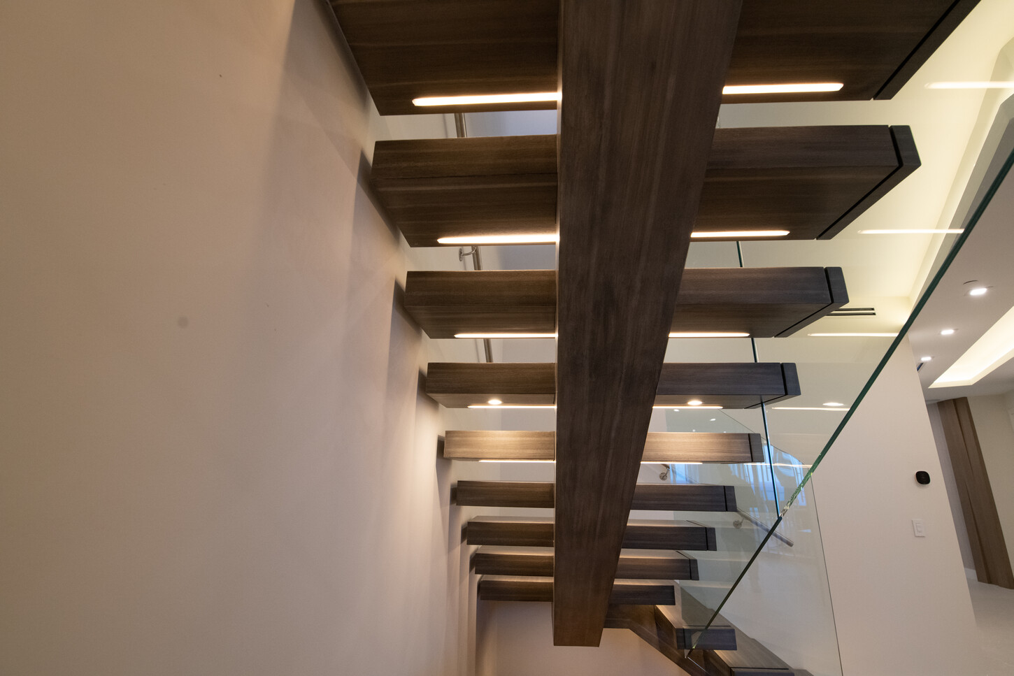 Integrated LED lighting beneath a floating staircase glowing at night, Fort Lauderdale skyline