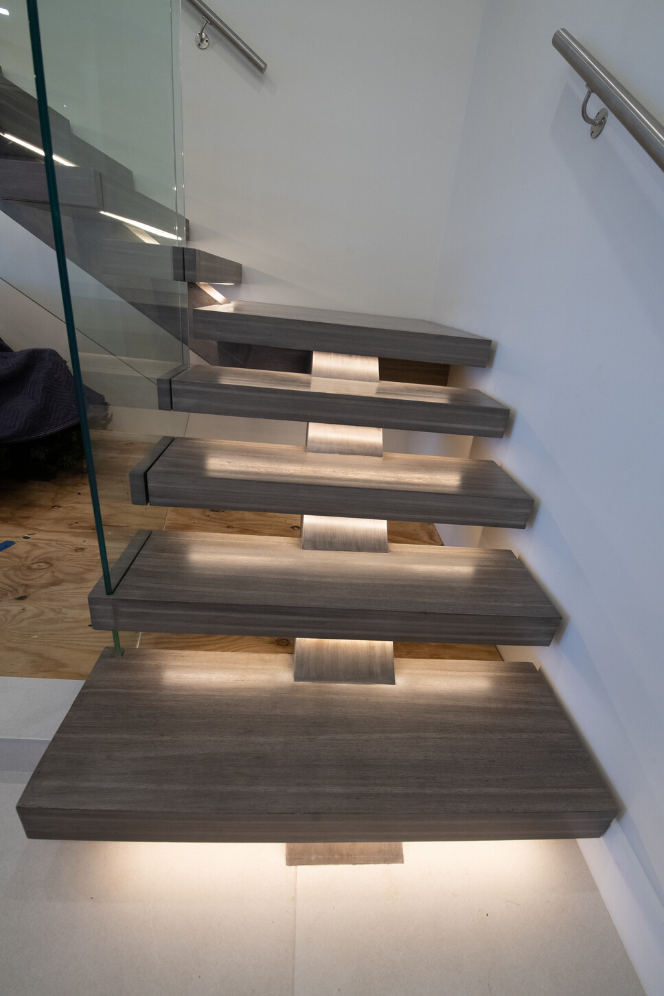 Custom staircase with structural glass and city skyline backdrop in Paramount Fort Lauderdale