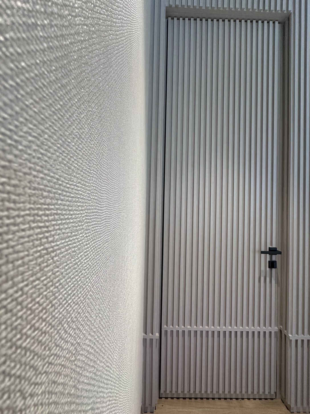 Glass pendant light detail beside a wood-slat wall in a Coral Gables bedroom