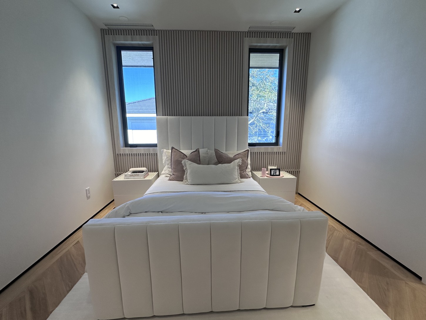 Guest bedroom with channel-tufted headboard and fluted wood wall paneling