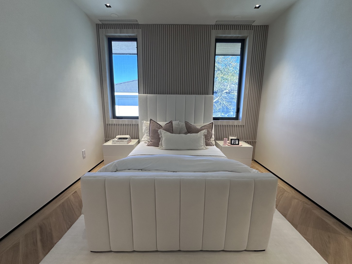 Wide view of a Coral Gables guest bedroom with tufted headboard and wood paneling
