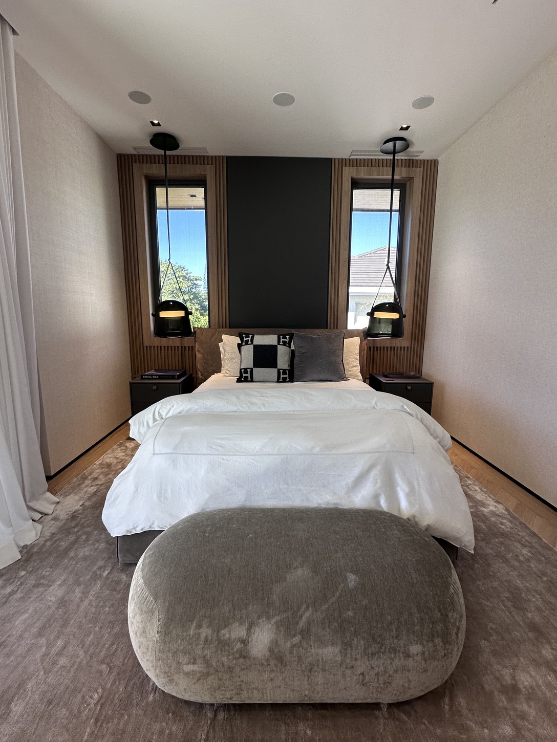 Custom wood-slat accent wall behind the bed in a Coral Gables primary suite