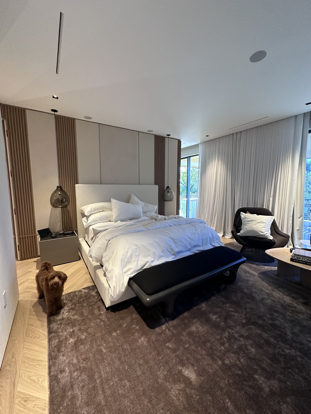 Wood-paneled primary suite wall with cylinder pendant lighting in Coral Gables