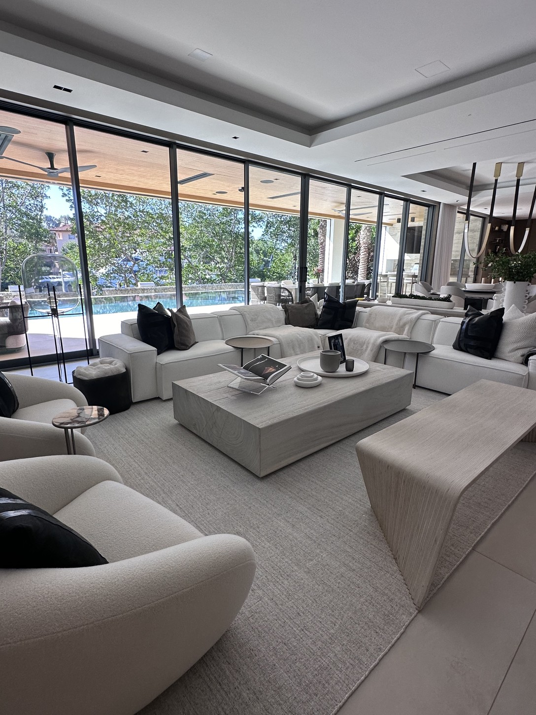 Round dining table positioned beneath the glass wine wall and staircase in a Coral Gables home